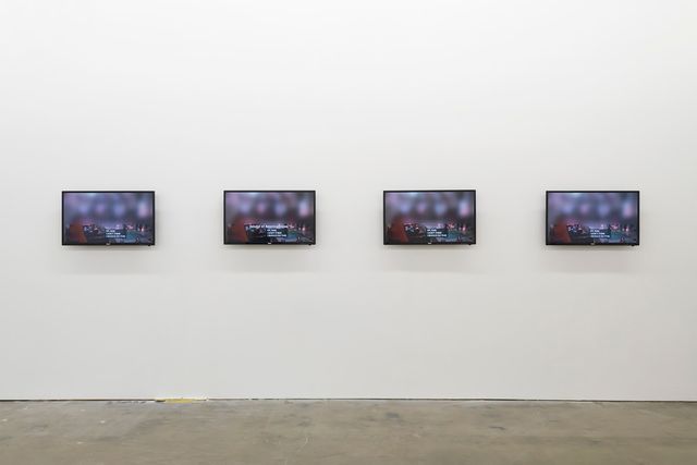 A photograph of four tv screens in an art gallery.