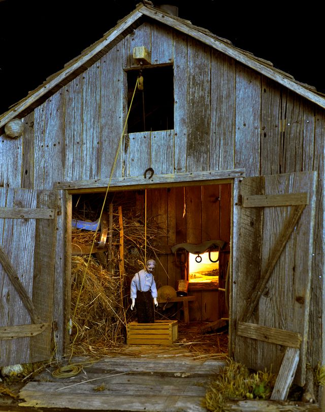 A photograph of a nutshell study of unexplained death showing a man's death by hanging inside a barn.