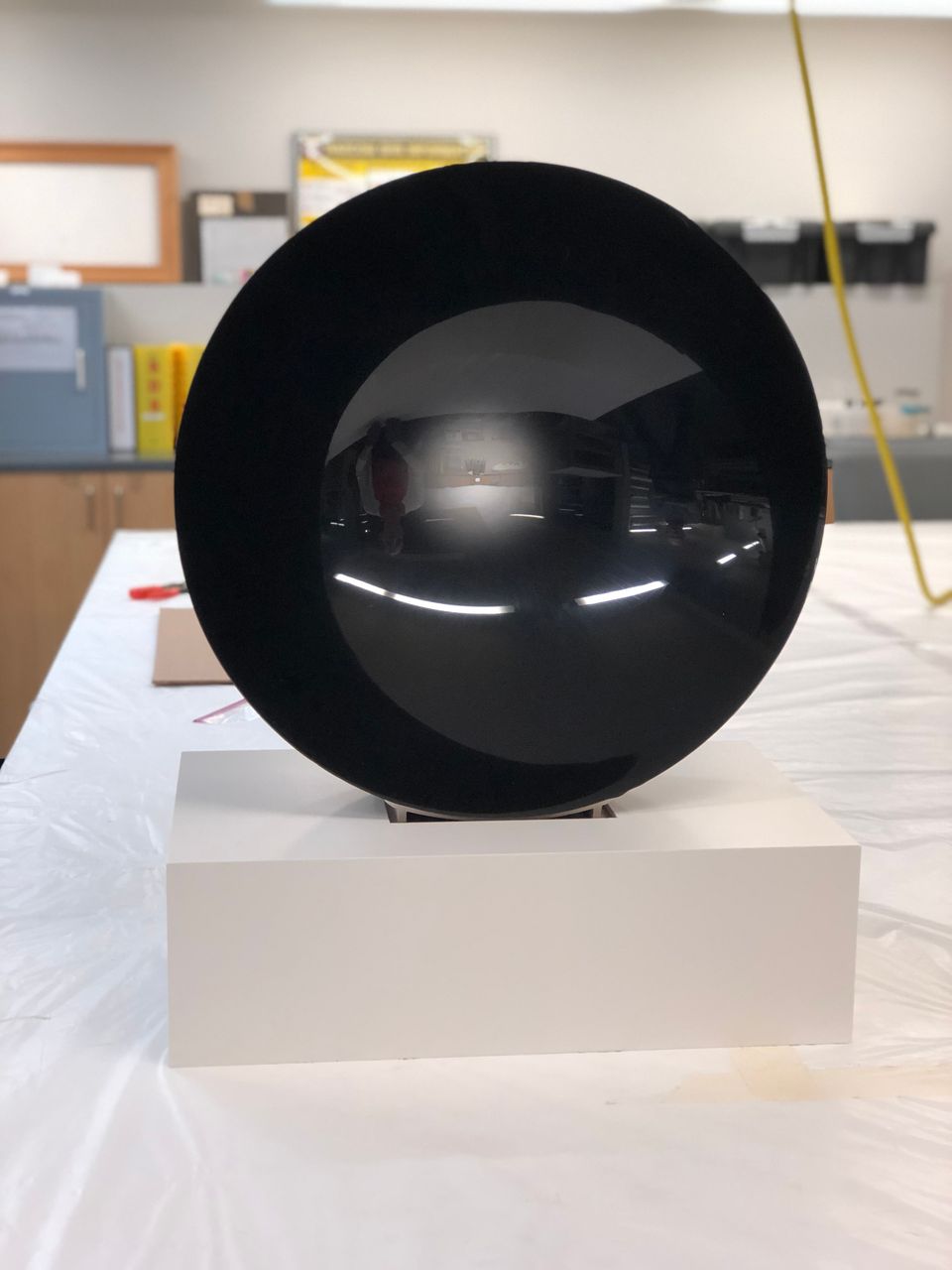 A rounded black Eversley piece is show on a white table in a conservation lab