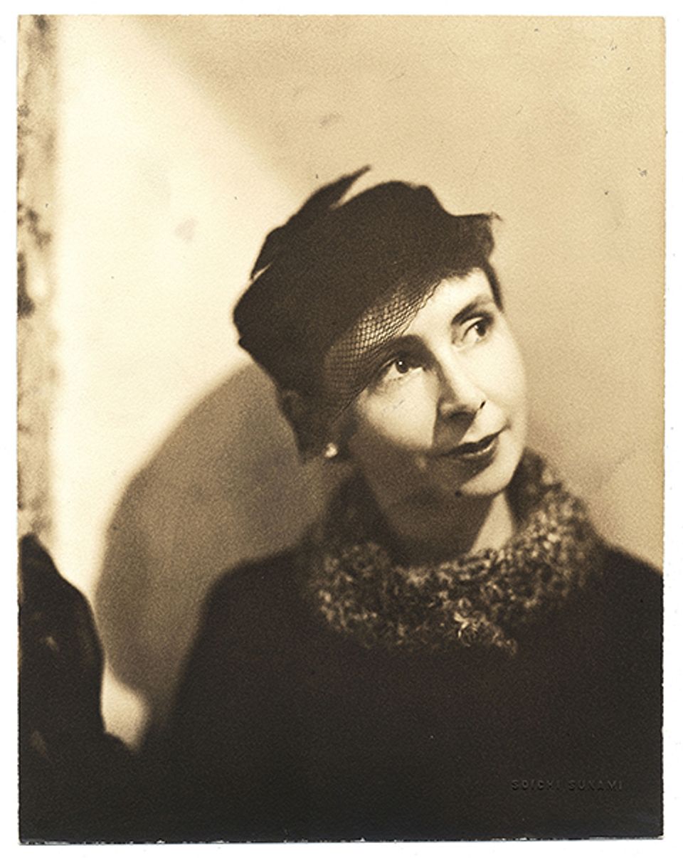 A photograph of a woman with a coat and a hat.