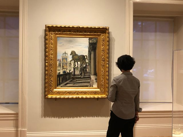 A person standing in front of a painting.