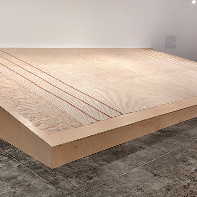 Large scale installation of fabric made of woven linen with madder dye, on a wodden board.