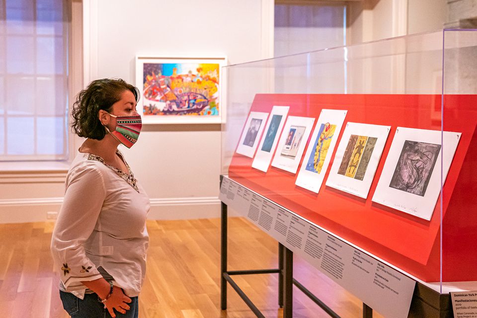A photograph of a woman looking at artwork