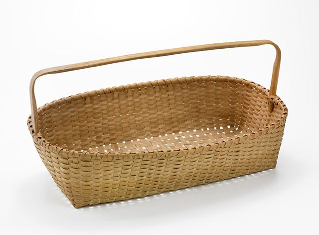A basket that is long and narrow with a handle.