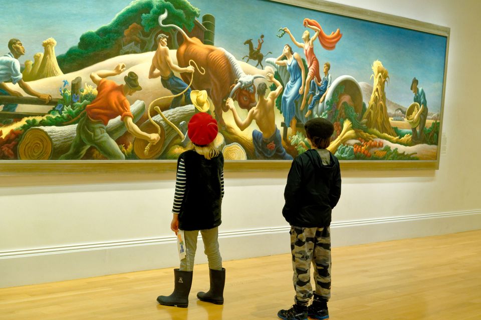 Two children look at a large and colorful mural 