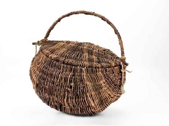 A basket with a circular base and handle.