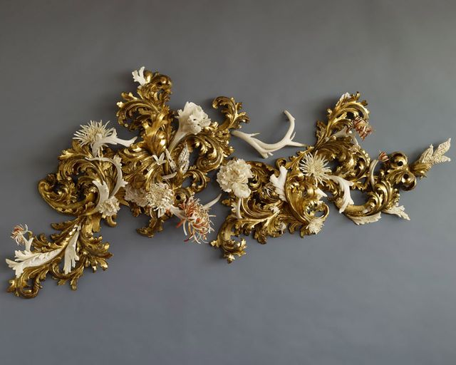 An image of a sculpture made of various materials and painted gold. 