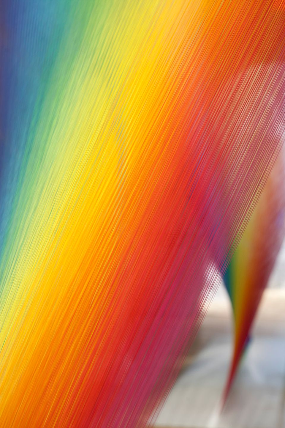 A detailed photograph of colorful string creating a rainbow affect.