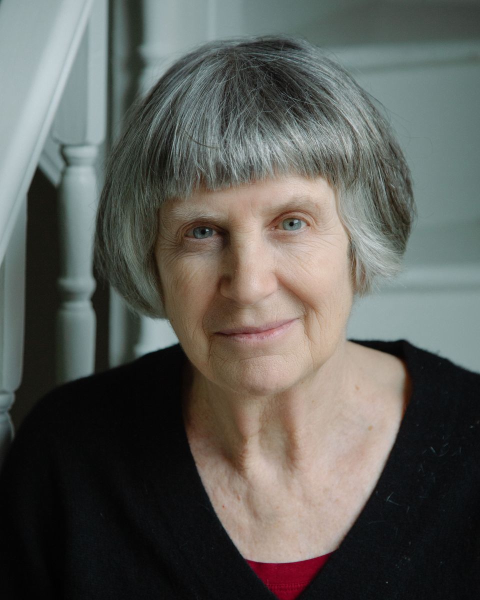 Filmmaker Vivienne Dick, a older woman with grey bob and bangs, stares out with slight smile