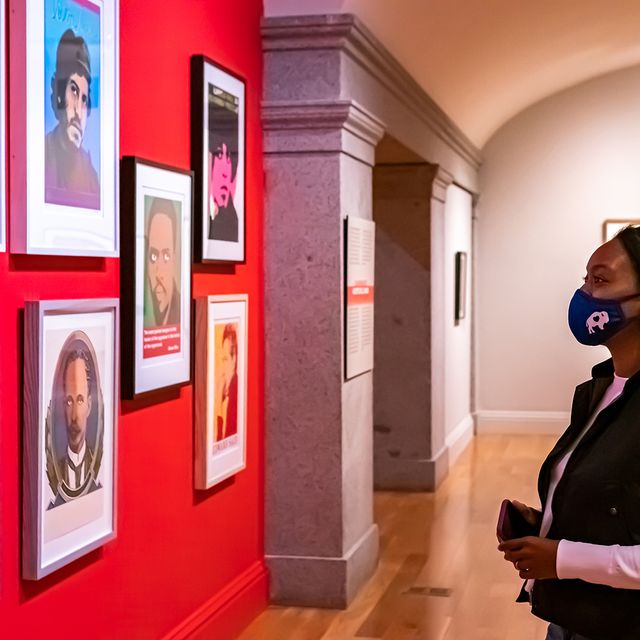 A photograph of a woman looking at artwork