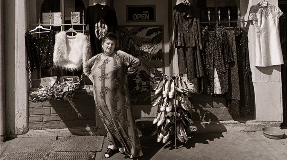 A black and white photograph of Edith Massey standing in front of her store.