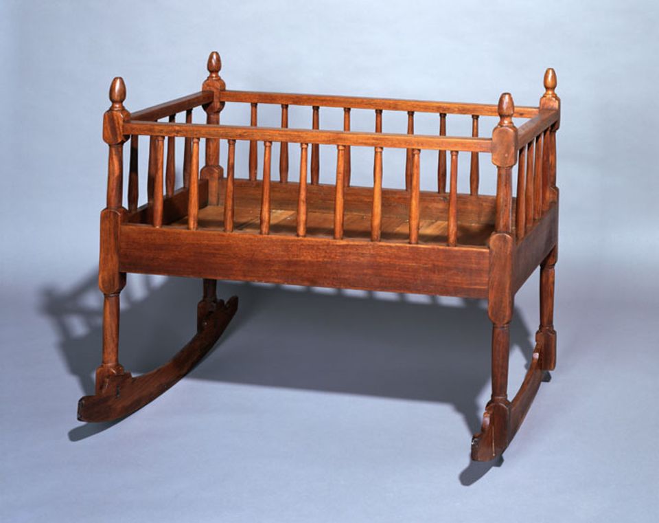 A walnut Windsor style cradle.