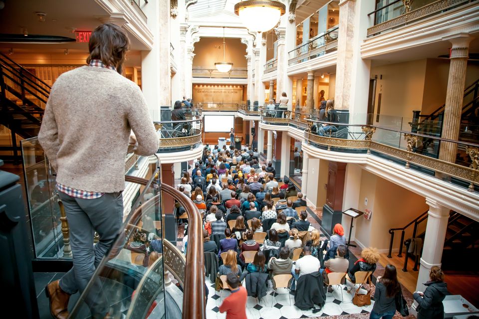Three floors of the Luce Center are shown with crowds of people moving around
