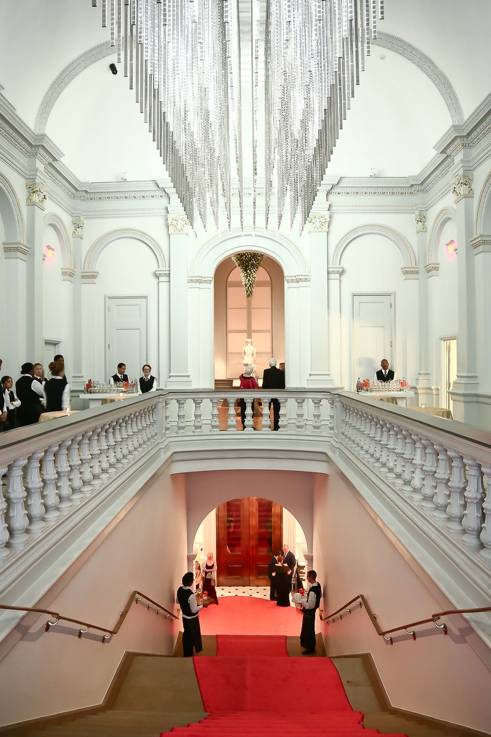 A photograph looking down a staircase at the Renwick Gallery with a red carpet.