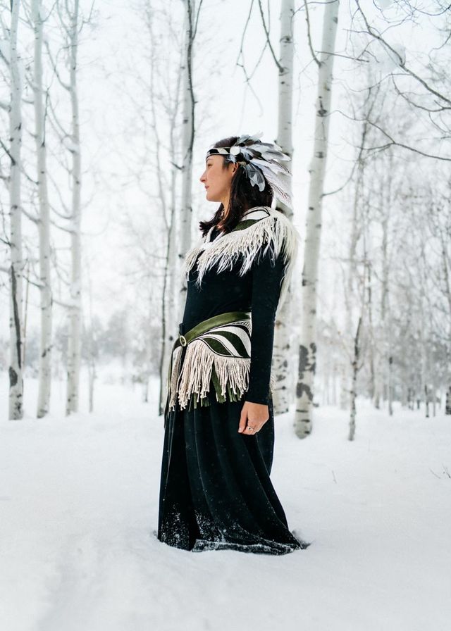 Photo of a woman modeling a handmade, traditional Native American outfit