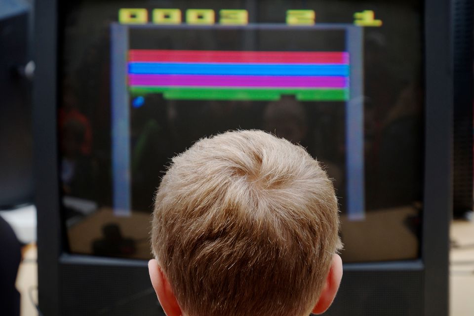 The back of a child's head with a video game in front of them.