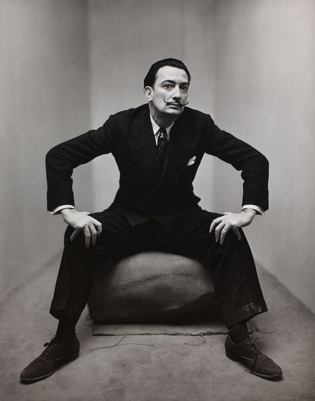 A black and white photograph of a man sitting down with a mustache.