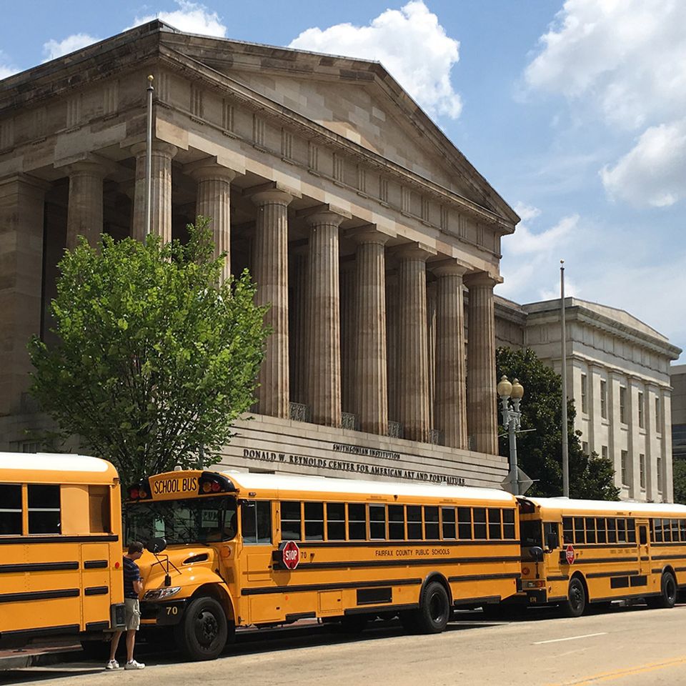 A photograph outside the Smithsonian American Art Museum with school busses.