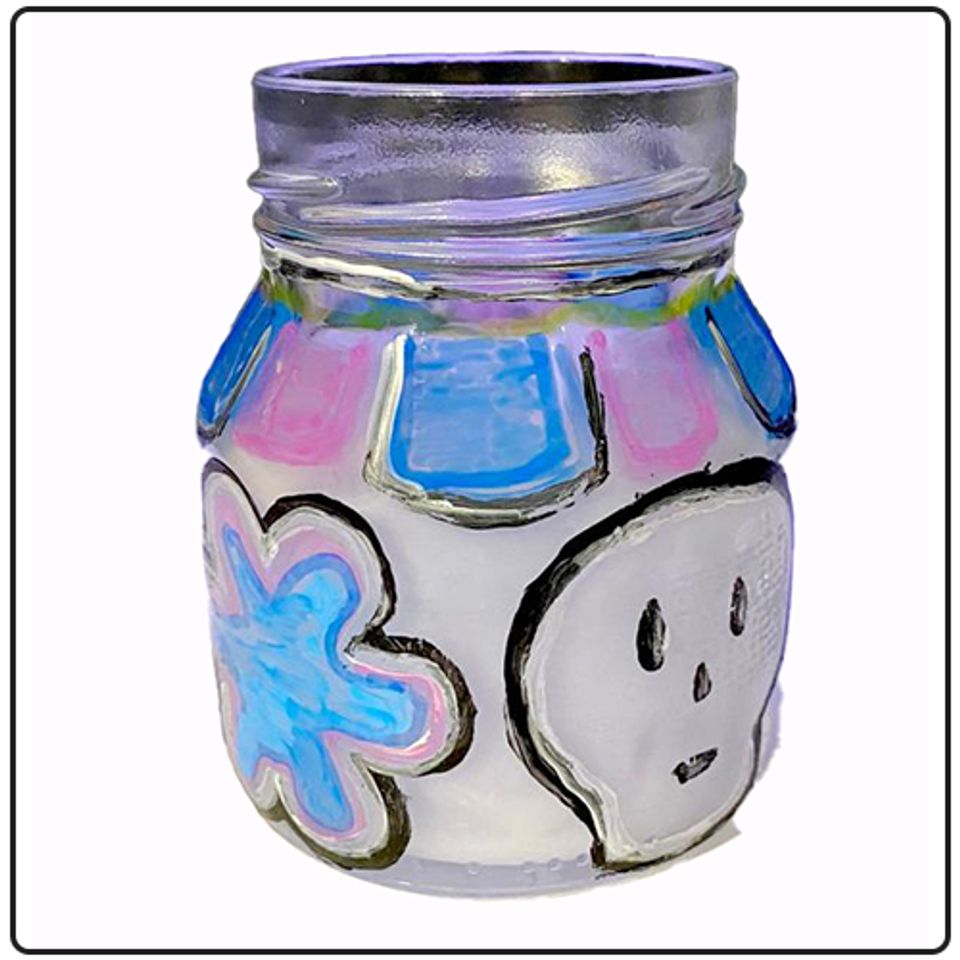 A glass candle holder painted with skulls and flowers.