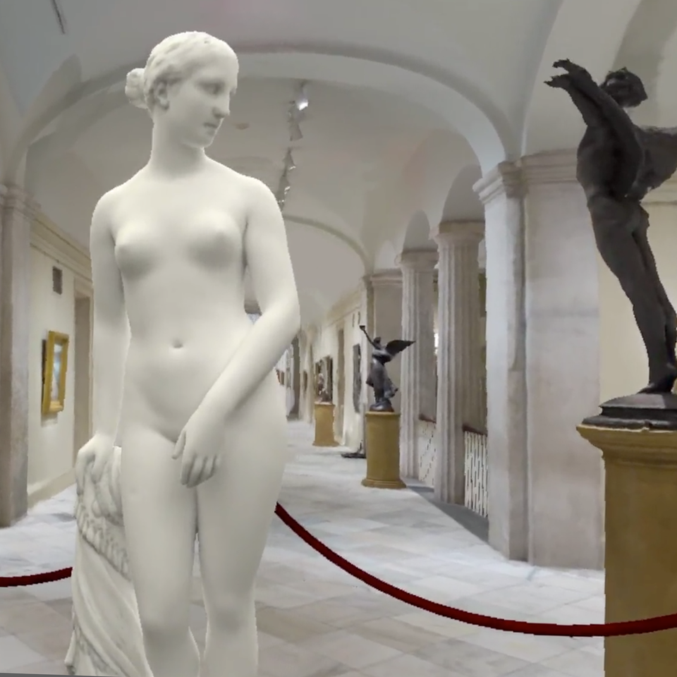 A white sculpture of a naked woman standing.