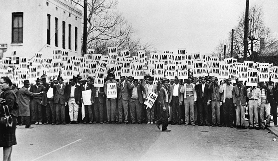 An image of figures lined up with signs that read "I AM A MAN" 