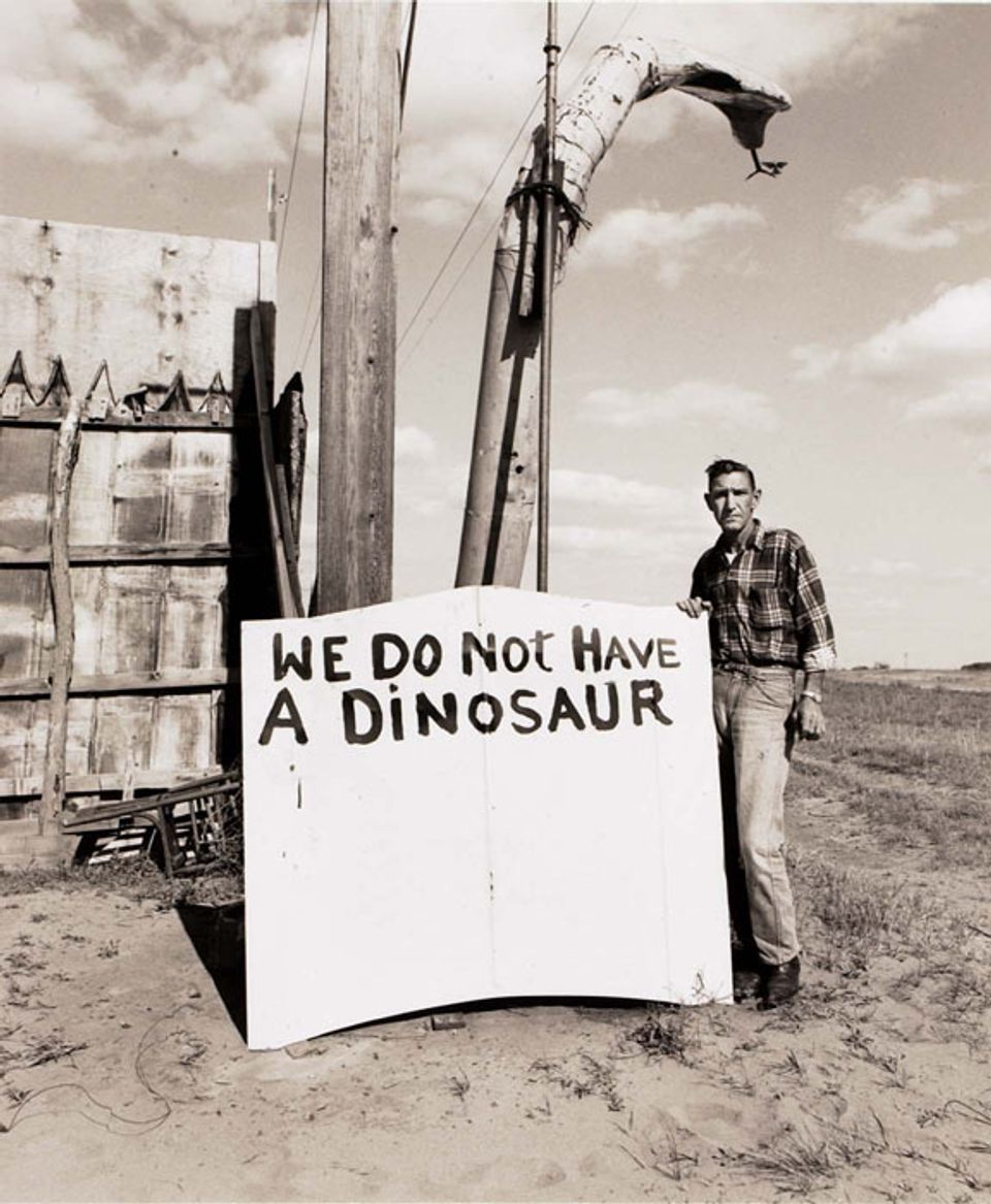 A photograph of a sign with a man saying "we do not have a dinosaur".