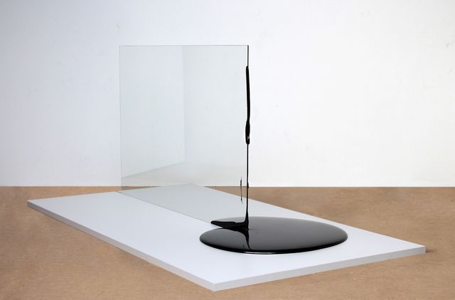 A gallery photograph of an artwork with a glass plane touching black material. 