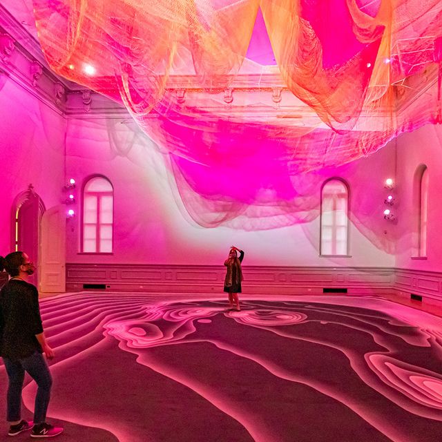 Three people looking up at an art installation inside the Renwick Gallery.