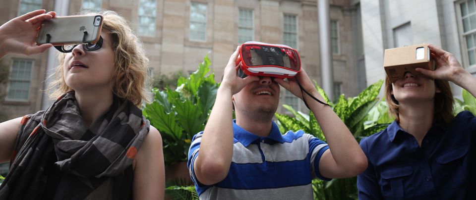 A photograph of three young adults wearing VR headsets. 