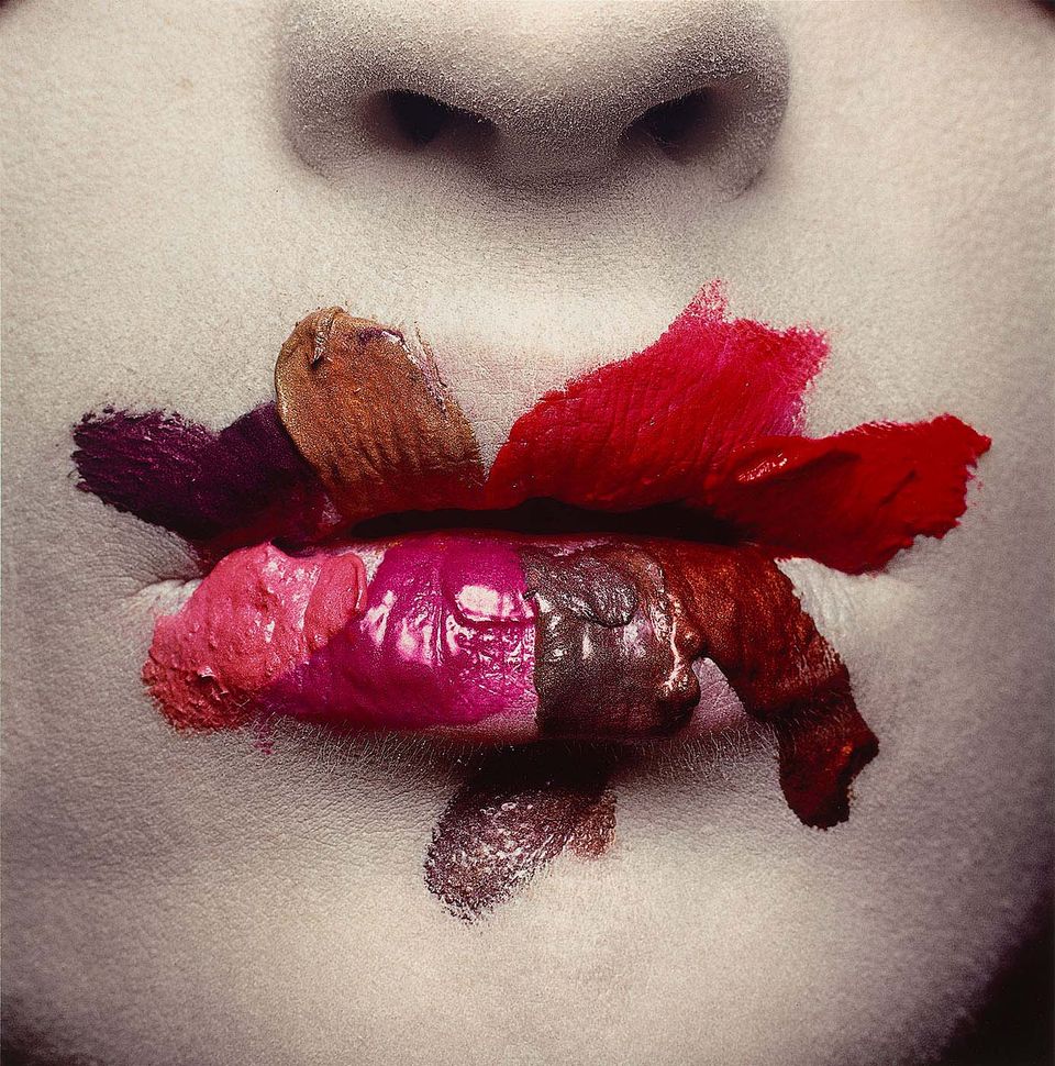 A detailed photograph of a mouth with 8 different lipsticks smeared on it.