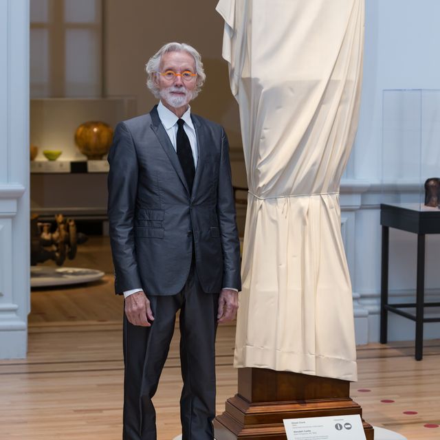 This is a photo inside the Renwick Gallery of artist Wendell Castle standing next to "Ghost Clock"