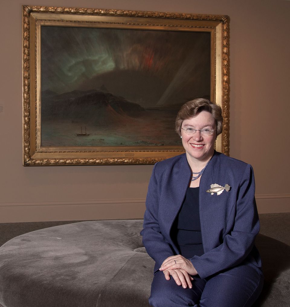 A photograph of Eleanor Harvey sitting in front of a painting.