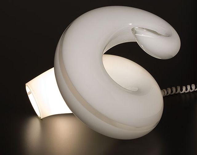 A white glass lamp that spirals in a circular form.