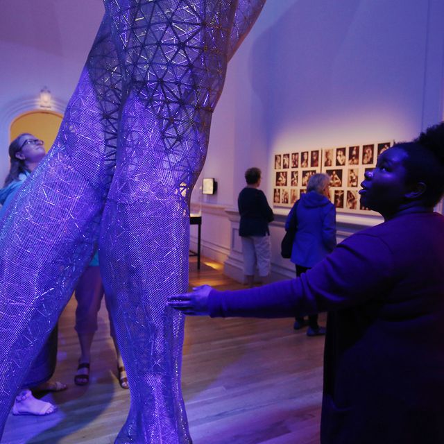 A picture of a woman touching the legs of a large sculpture piece at the Renwick Gallery.