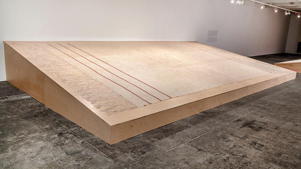 Large scale installation of fabric made of woven linen with madder dye, on a wodden board.