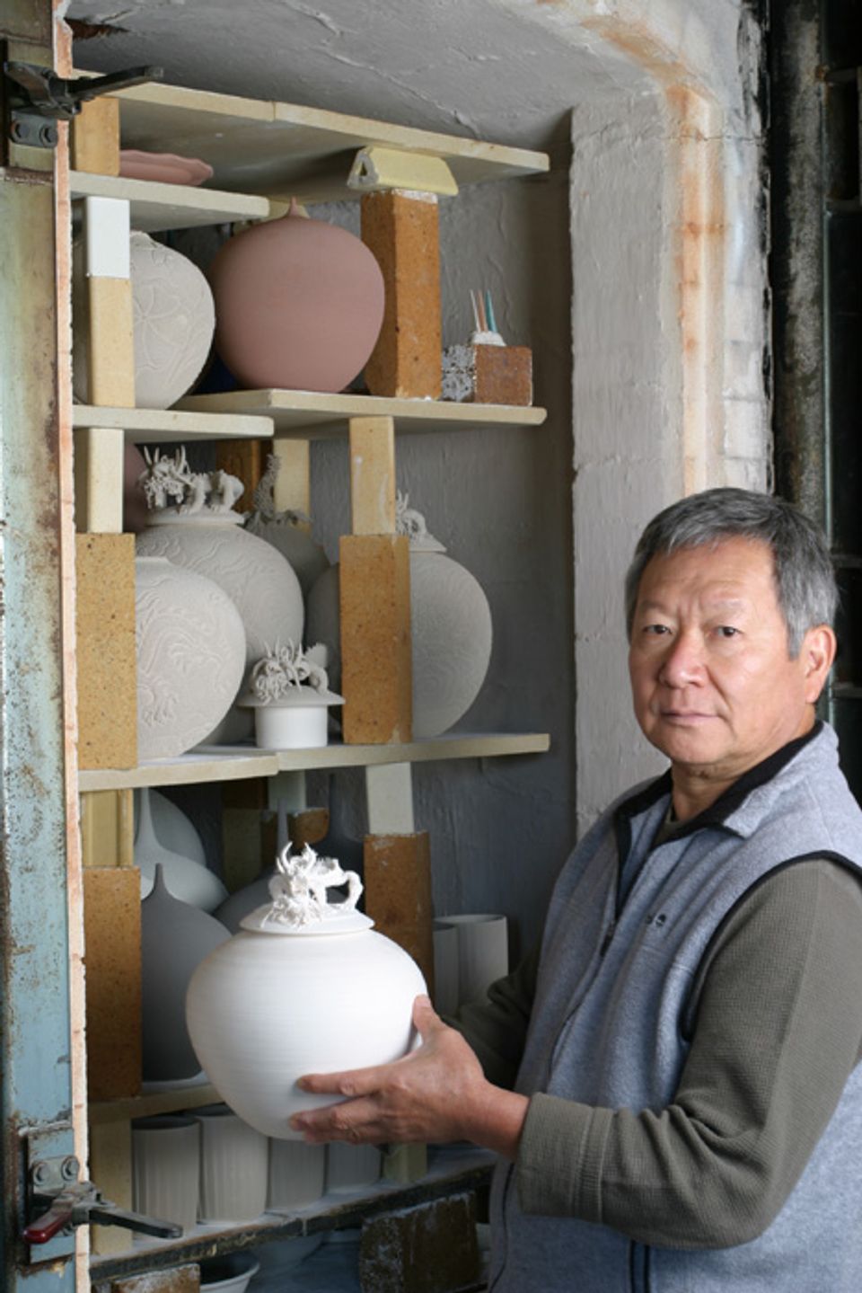 An image of Cliff Lee in his studio holding a porcelain bowl.