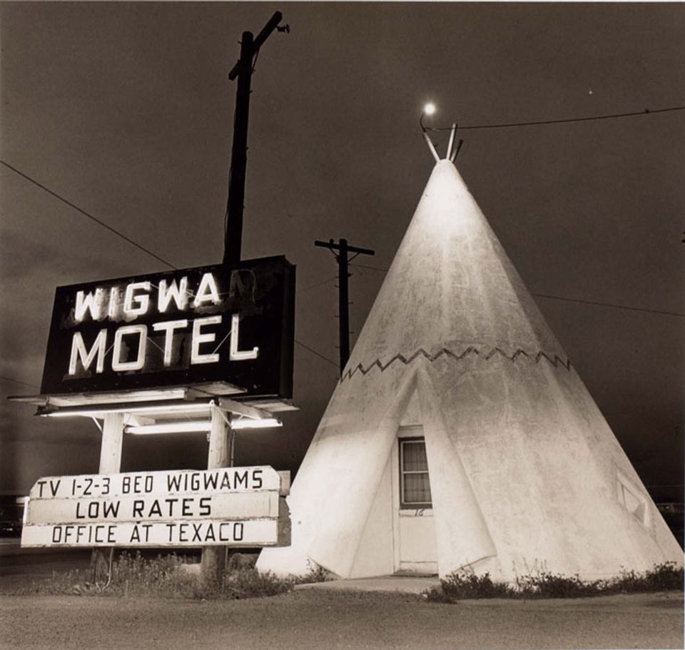 A photograph of a motel in Arizona with a teepee outside. 