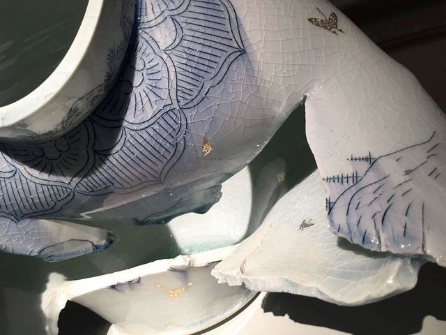 A detail shot of a porcelain jar that has a hole in it.