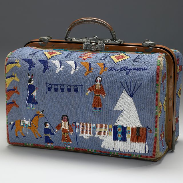 A blue suitcase made of beads with designs of people, a teepee, and animals.