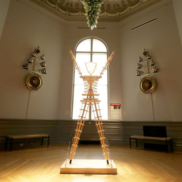 An image with a wooden man in the center and instruments on the walls.