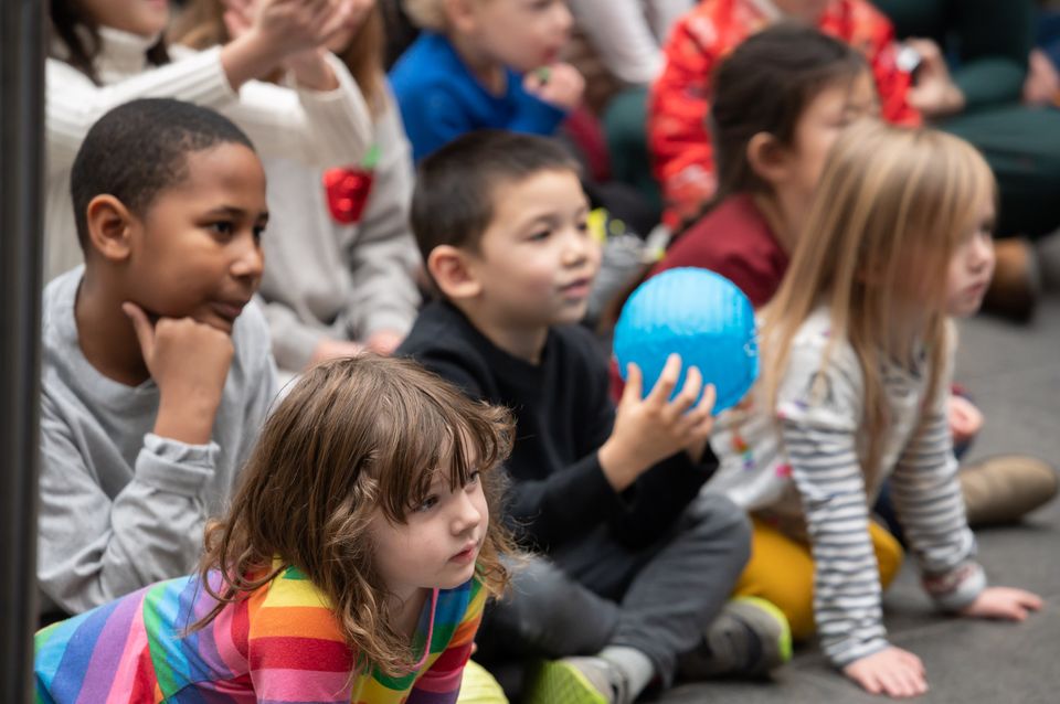 A group of small children look attentive at a family day event