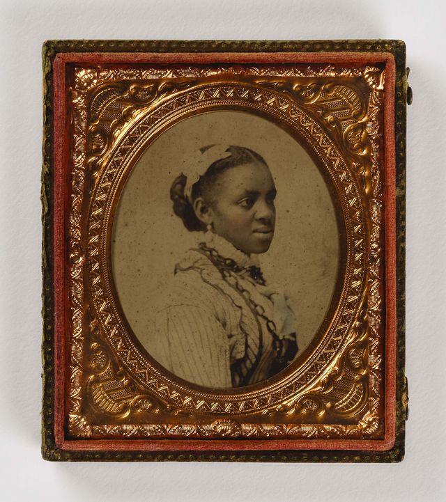A black woman is shown in profile surrounded by a gilded frame