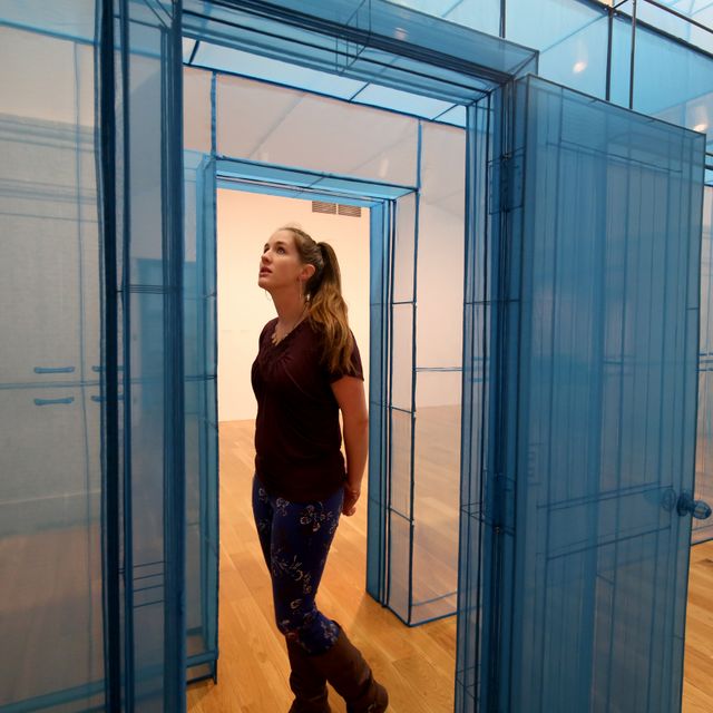 Woman standing next to blue hub sculpture