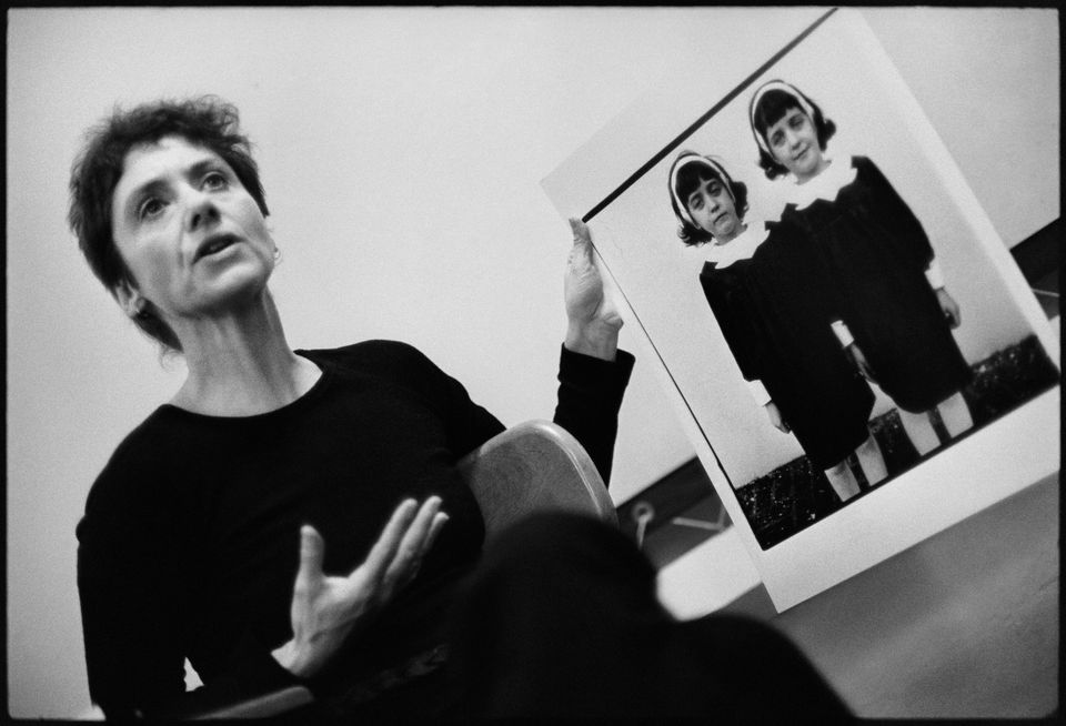 A photograph of Diane Arbus from 1966 holding her photo Identical Twins