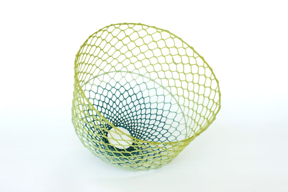 An artwork resembling a basket made from green hues. 