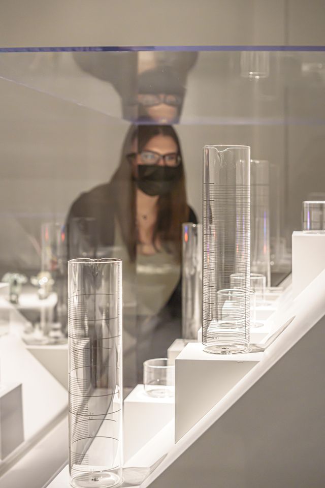 Woman looking at glass objects in museum case
