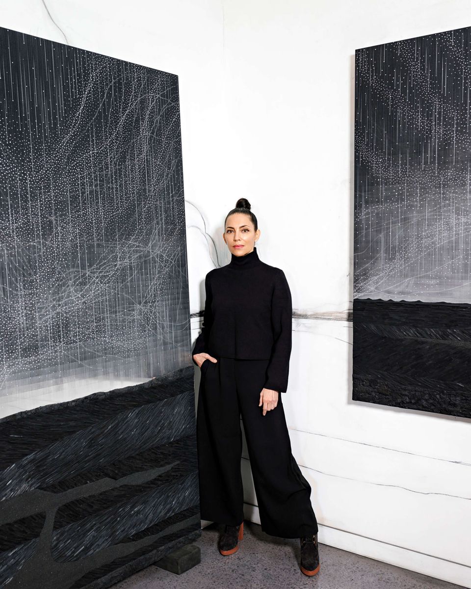 Teresita Fernández poses between two of her artworks.