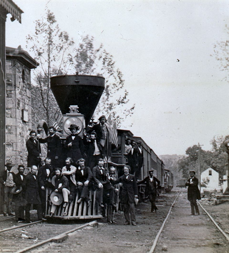 A salt paper print of men posing with a railroad car. 