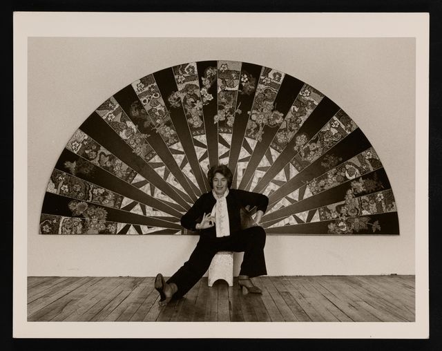 Photograph of Miriam Schapiro with her work, ca. 1981. Photo by Ellie Thompson. Miriam Schapiro scrapbooks, 1951-1981, Archives of American Art, Smithsonian Institution