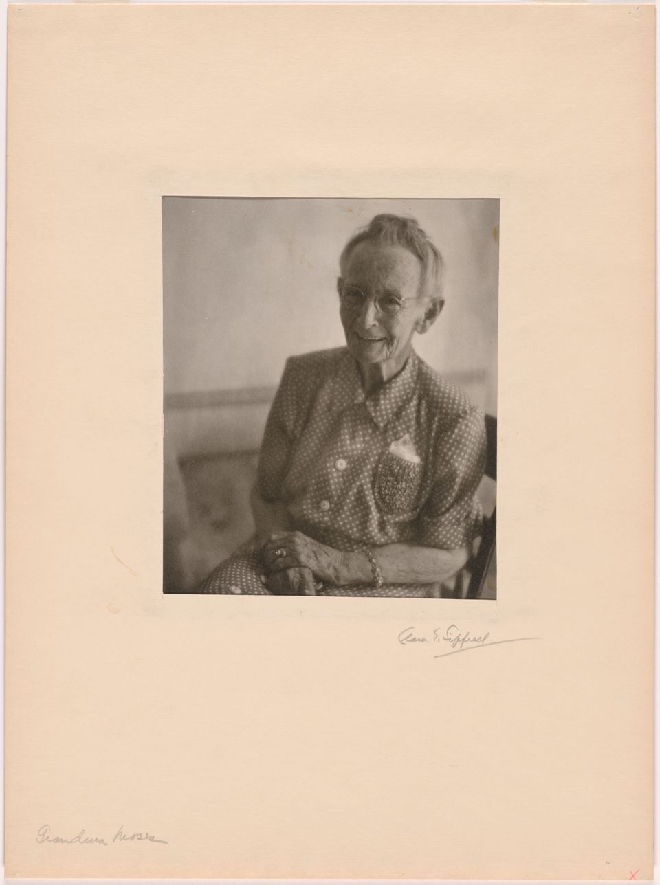 Grandma Moses sits posing in a chair